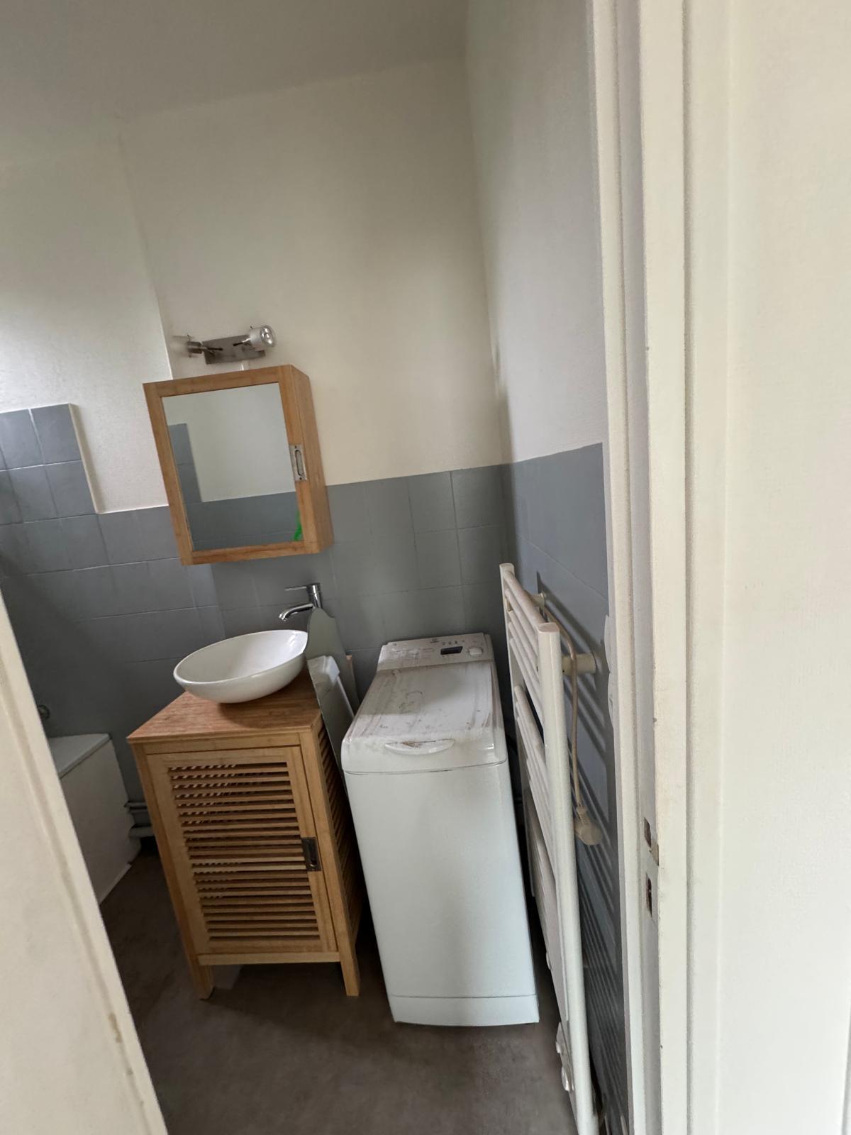 Coin lavabo et lave-linge de la salle de bain avant travaux